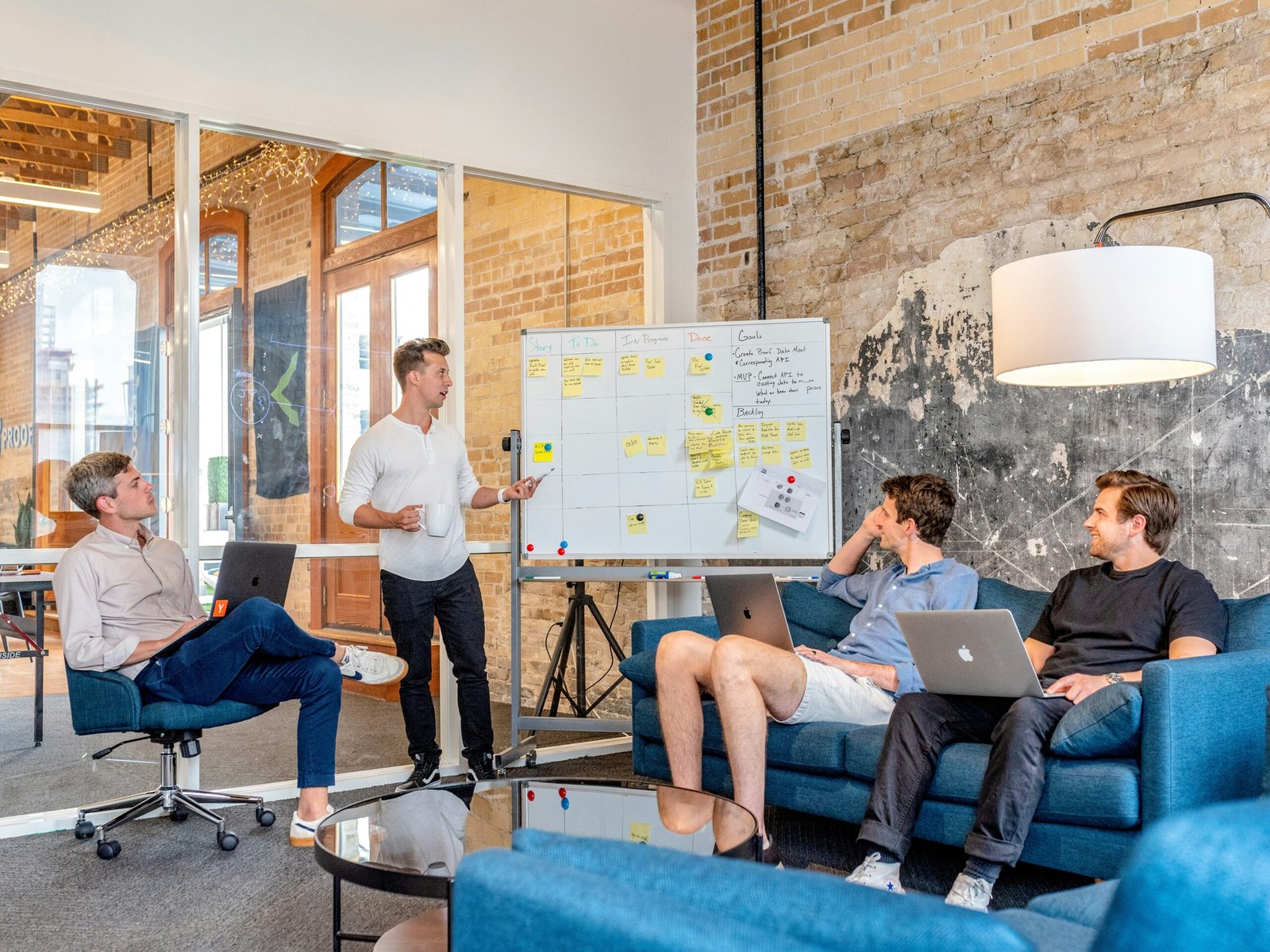 Une équipe discute devant un tableau rempli de post-its, illustrant l’importance de relier les indicateurs d’expérience employé et d’expérience client.